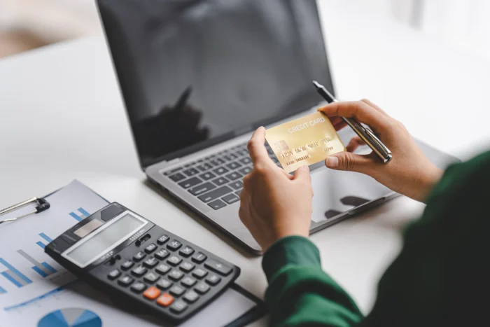 Where Are Capitation Payments Entered in Medisoft? - female hand holding credit card and paying online Use banking, enter information, shop, order in Int