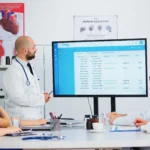 Specialist doctor presenting to colleagues the waiting list of patients - Computer Mate - Medical Software